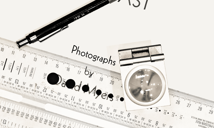 Close-up of a type ruler, magnifying glass and a mechanical pencil