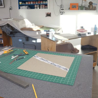 Worktable with paper-cutting tools and the press in the distance