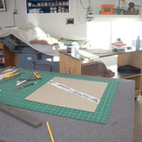 Worktable with paper-cutting tools and the press in the distance