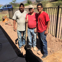 Three workers posed in dungarees and with a shovel